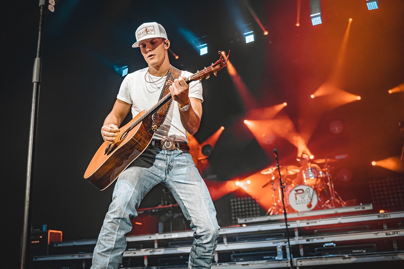 Parker McCollum performing onstage with a guitar